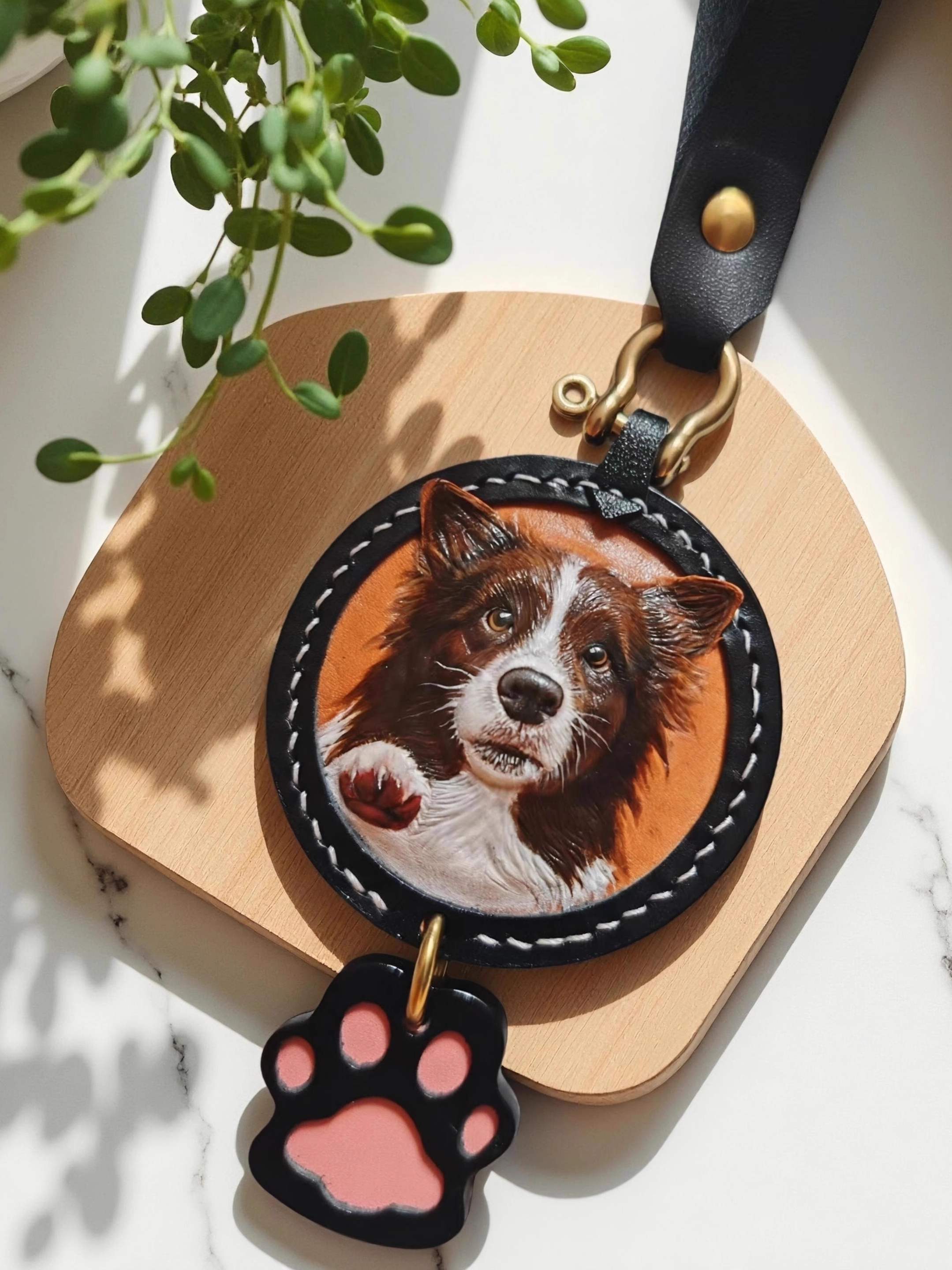 Custom-made luxury leather pet keepsakes and gifts featuring pet portraits, including cat and dog keychains.