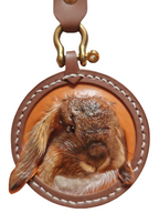Custom-made luxury leather pet keepsakes and gifts featuring pet portraits, including cat and dog keychains.
